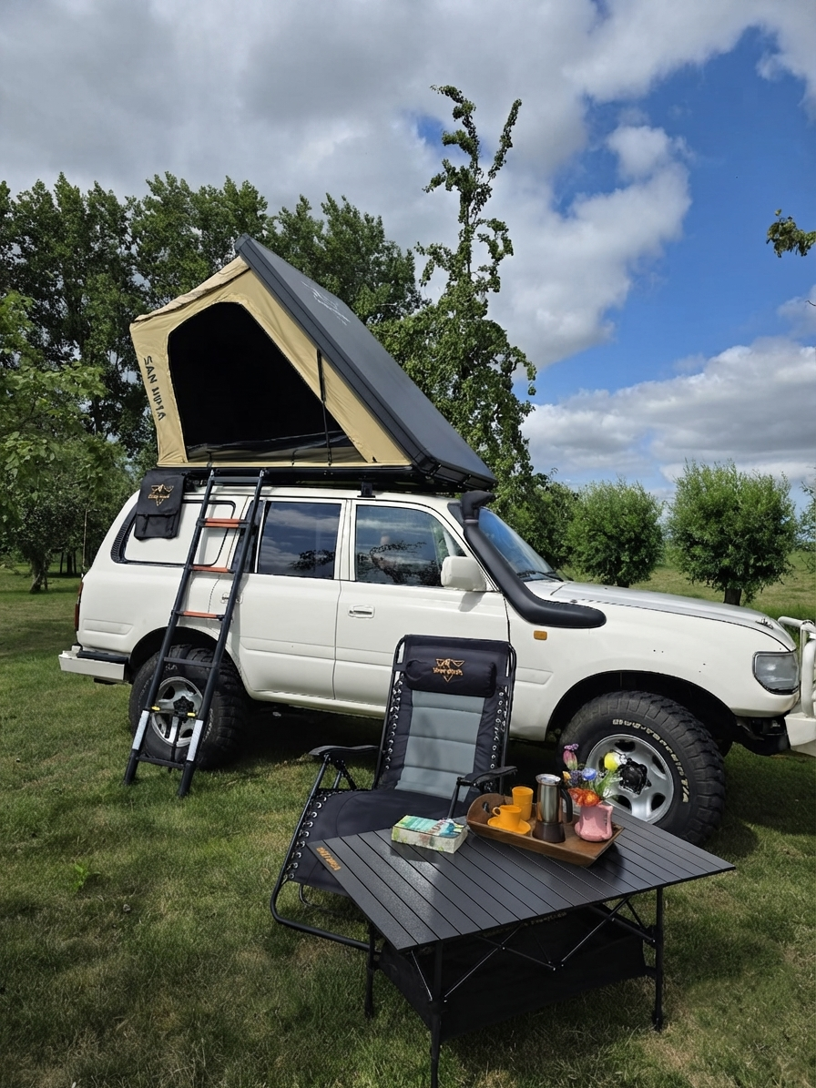 LCM Savannah hardshell daktent in khaki opengeklapt op een witte Toyota Land Cruiser, met SAN HIMA campingstoel en aluminium tafel in het weiland