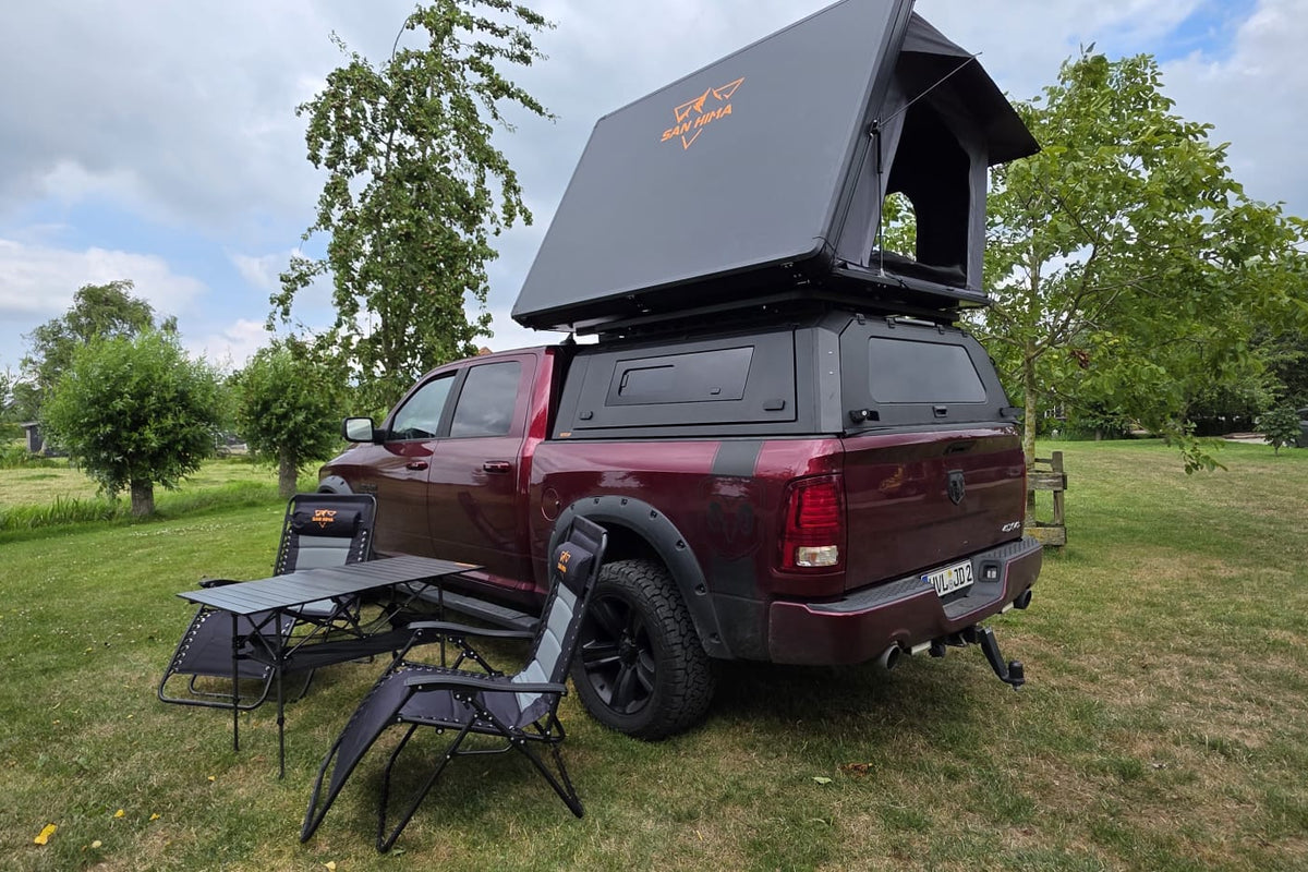 RAM pick-up met LCM Oasis daktent, SAN HIMA campingstoelen en campingtafel op het gras