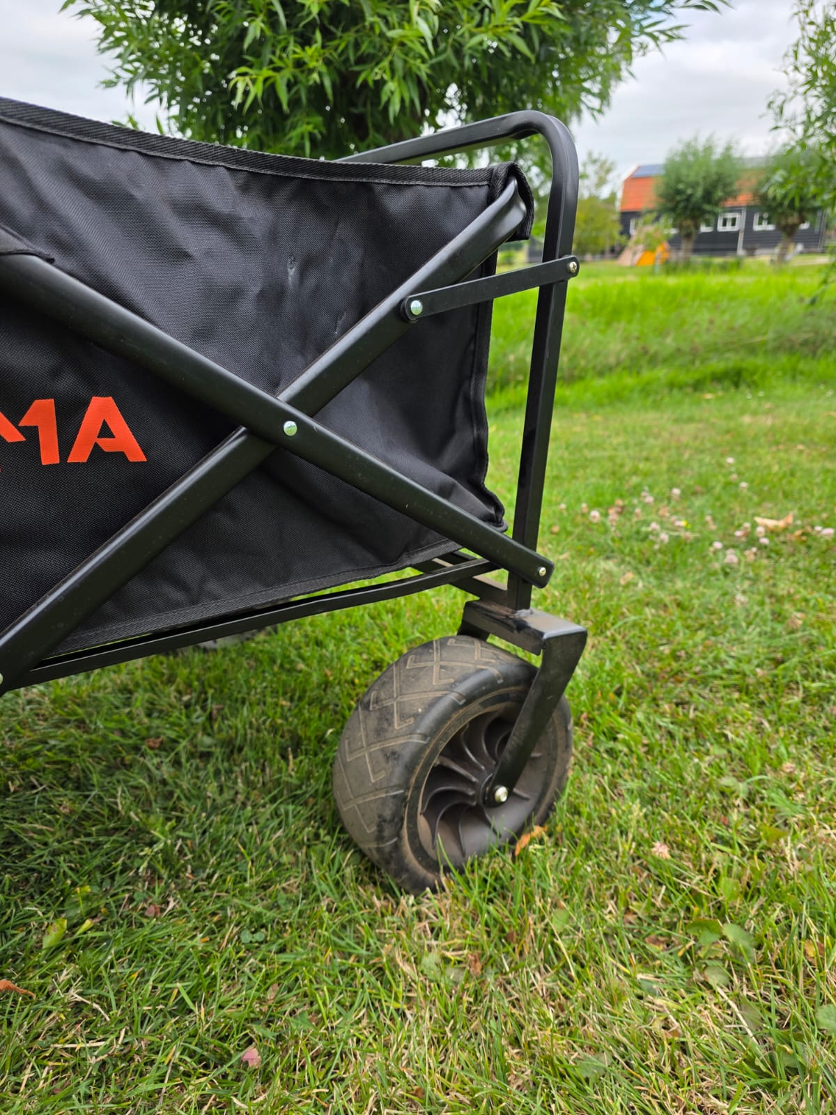 Close-up van het brede offroad wiel en stalen vouwframe van de opvouwbare bolderkar