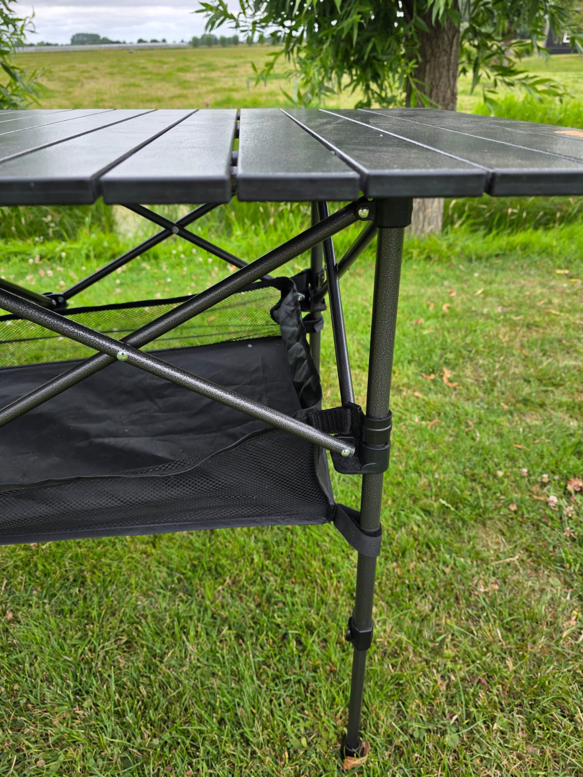 Close-up telescopische tafelpoot en opbergnet van de aluminium campingtafel