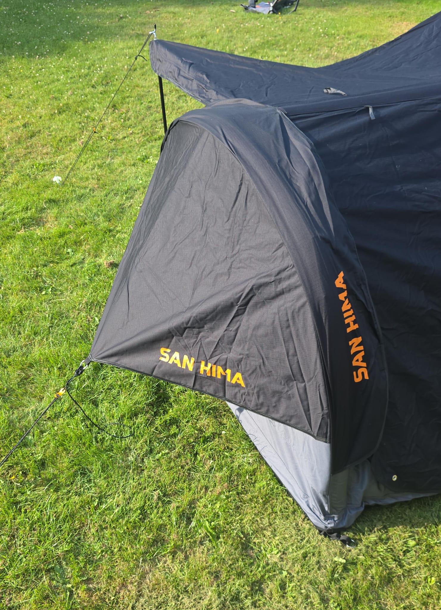 Close-up SAN HIMA luxe tent met ingang en scheerlijnen op het gras